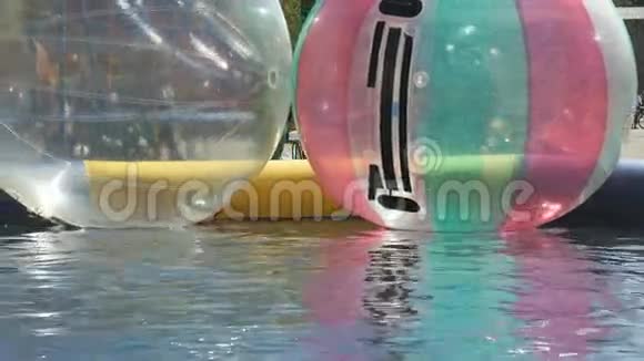 打开的游泳池里有大的充气球天气晴朗视频的预览图