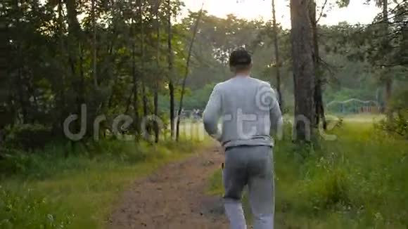 戴着棒球帽的年轻运动员穿过树林视频的预览图