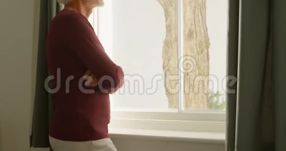 老人在卧室透过窗户看家视频的预览图