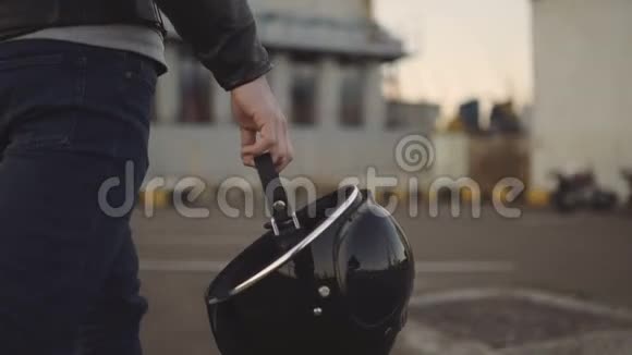 一个年轻人骑着摩托车坐在摩托车上戴上头盔去旅行视频的预览图