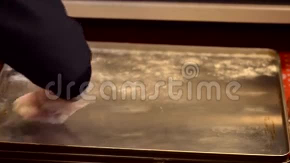 面包师撒上面粉烤箱托盘视频的预览图