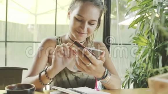 女人在咖啡馆里使用网上银行和智能手机视频的预览图