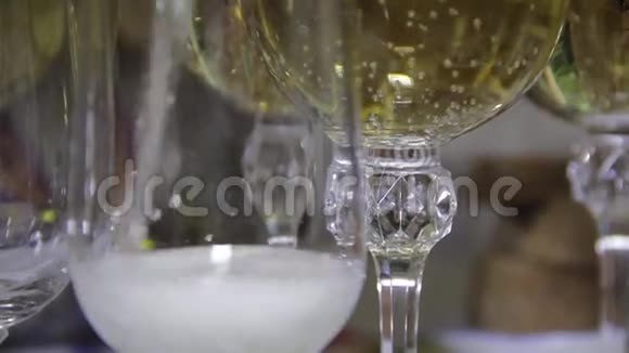 将香槟酒倒入节日桌上的酒杯中视频的预览图