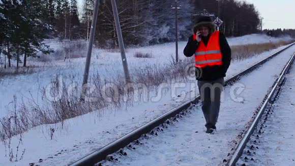 铁路员工冬天在铁路上使用智能手机视频的预览图