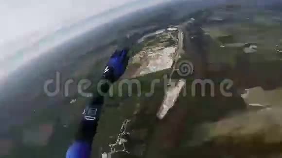 专业跳伞员在绿色平原上空灰色的天空中打开降落伞景观视频的预览图