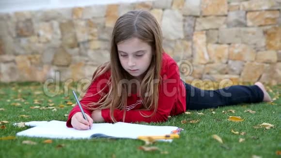 金发女孩数学作业躺在草地上用手指写数数视频的预览图