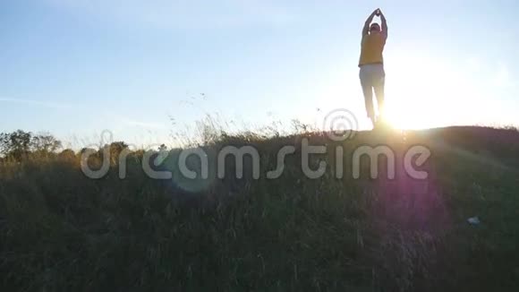 日落时分年轻人在山上练习瑜伽动作和姿势在大自然中站在瑜伽姿势的运动男美丽美丽视频的预览图