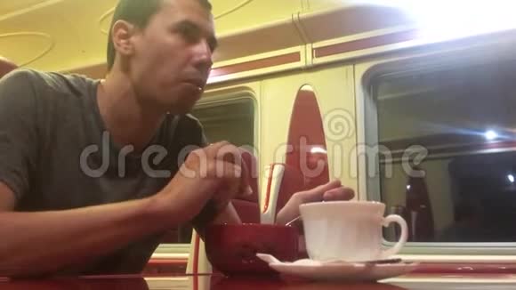 男人晚上在火车餐厅吃汤铁路猫喝咖啡火车上的男人概念旅程生活方式视频的预览图