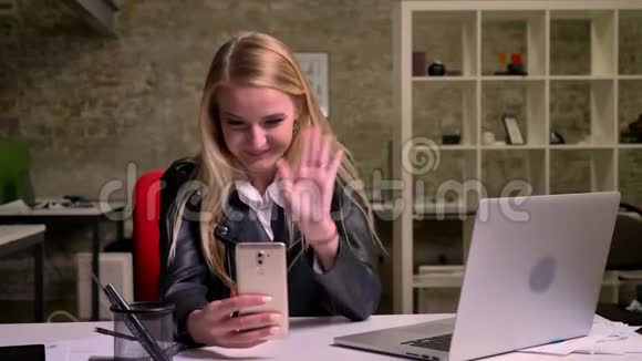 一位精力充沛的白种人女士正在用她的手机打视频电话愉快地交谈着看着网络摄像机视频的预览图