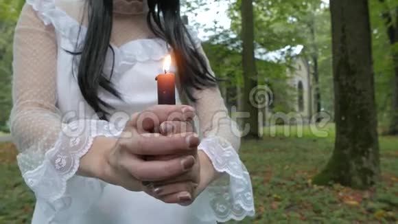 女孩看着燃烧的蜡烛教堂在一个视频的预览图