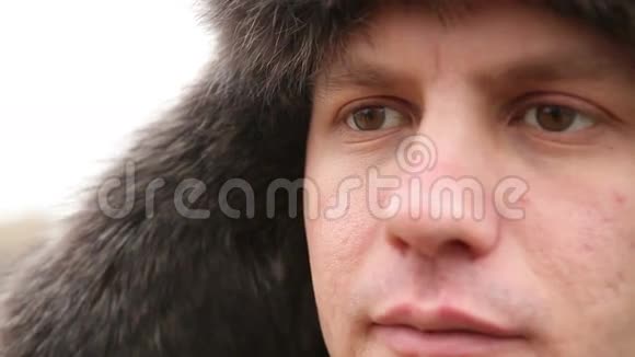 一个戴着冬毛帽的男人的肖像视频的预览图
