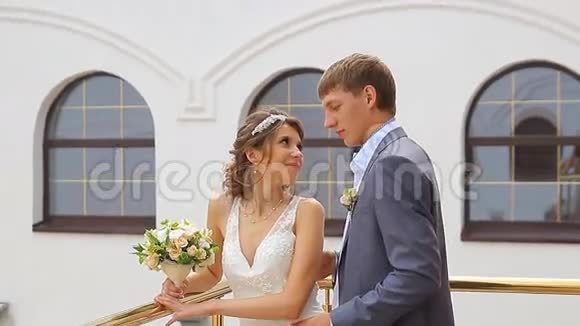 漂亮的年轻夫妇站在阳台上视频的预览图