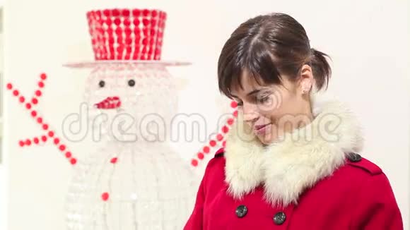 圣诞妇女打开书包露出惊讶的微笑背景中的雪人视频的预览图