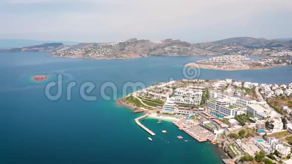 中午鸟瞰海洋海岸的酒店和白色房屋视频的预览图