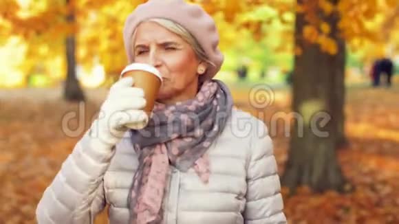 秋天公园喝咖啡的老妇人视频的预览图