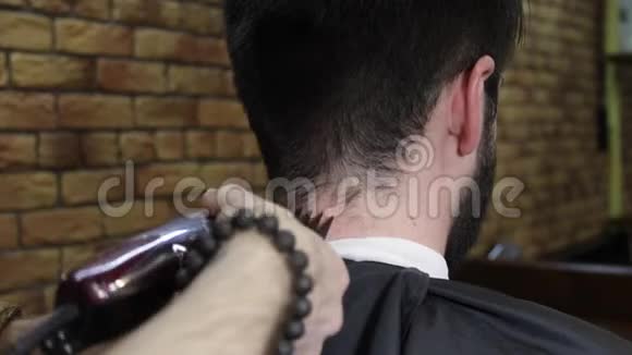 理发师用理发工具剪了客户黑发男子的头发视频的预览图