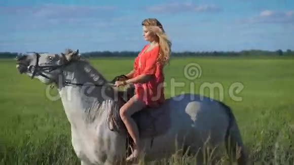 一个美丽的金发女孩在乡下骑马视频的预览图