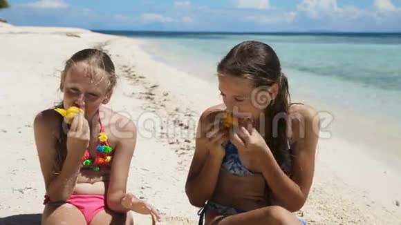 在海滩上吃芒果水果的年轻女孩视频的预览图