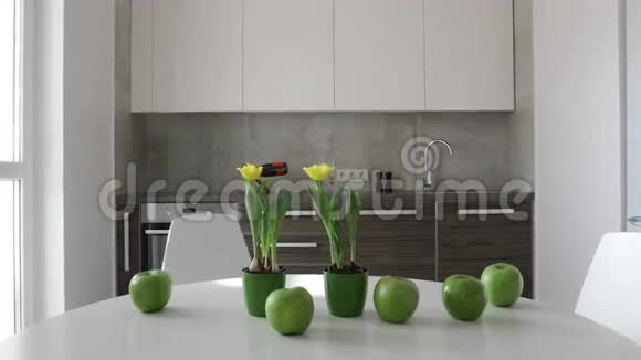 4K斯堪的纳维亚风格的现代厨房内部苹果和鲜花的运动全景视频的预览图