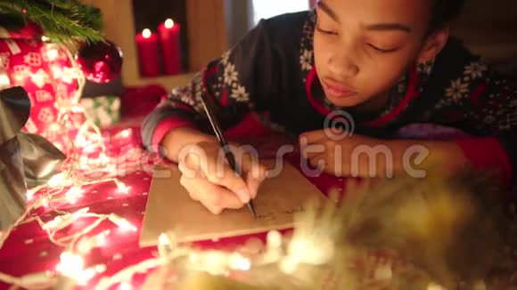 少女躺在装饰好的圣诞树旁给圣诞老人写信视频的预览图
