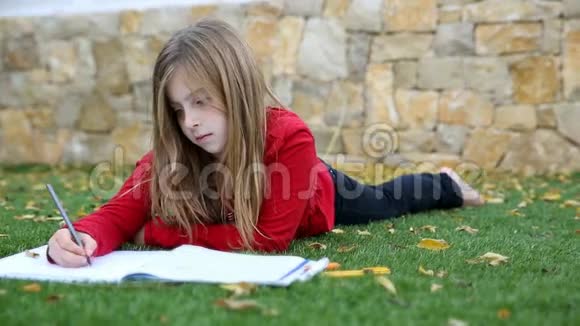 金发女孩数学作业躺在草地上用手指写数数视频的预览图