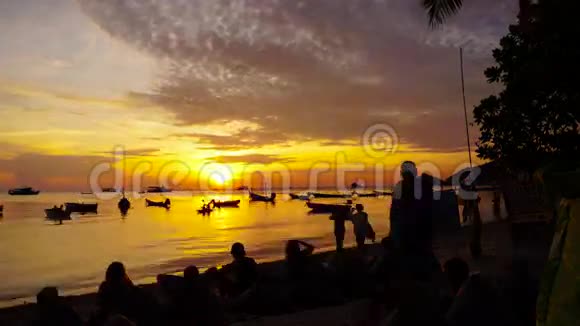 日落时分人们在海滩上和船上视频的预览图