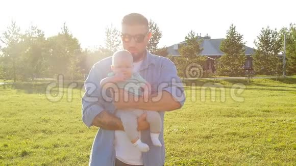 快乐的父亲抱着他的儿子日落视频的预览图