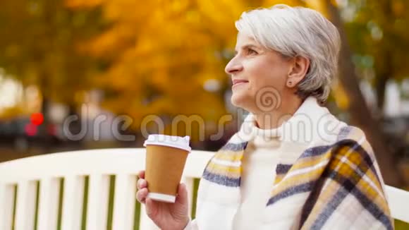 秋天公园喝咖啡的老妇人视频的预览图
