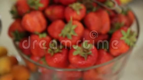 新鲜成熟多汁的草莓在白色的背景下在白色的盘子上旋转视频的预览图