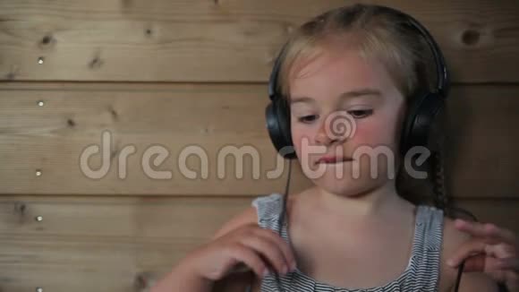 女孩在耳机上听音乐视频的预览图