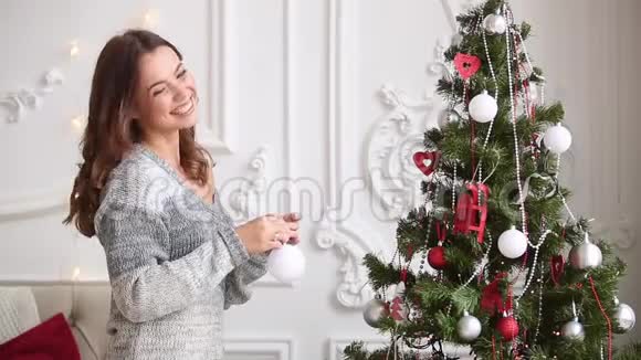漂亮的女人正在装饰圣诞树视频的预览图