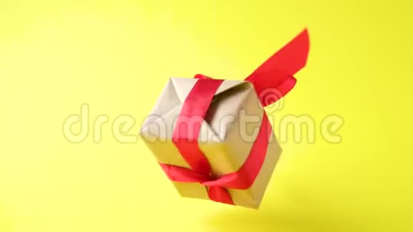 礼品盒红色丝带在黄色背景上旋转360度旋转零重力悬浮共空间概念销售d视频的预览图