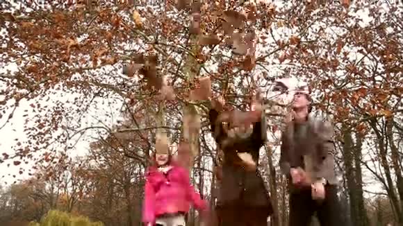 快乐的一家人在公园里向空中扔树叶视频的预览图