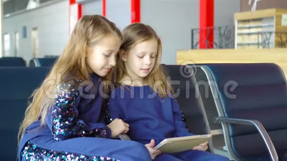在机场等待登机的小可爱女孩玩手提电脑视频的预览图