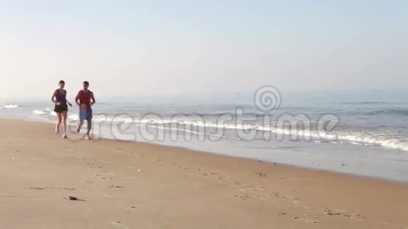 一对夫妇在空海滩跑步视频的预览图