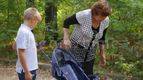 祖母带着孙子在公园散步视频的预览图