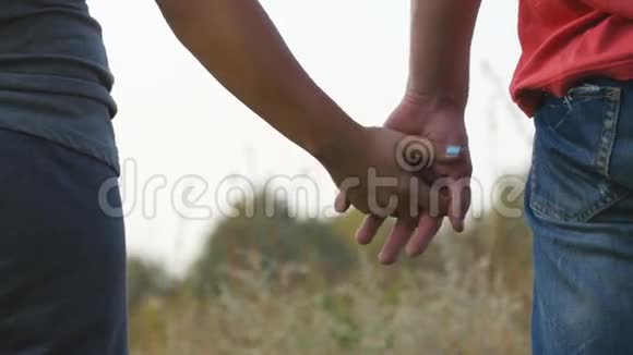 年轻夫妇在户外牵手男人和女人在自然背景上拿起武器男性和女性的双手安慰视频的预览图