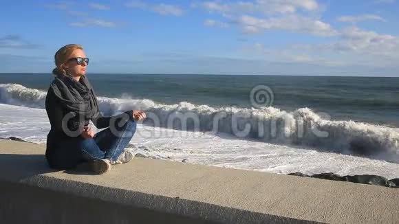 那个女人在暴风雨中在海滩上冥想平衡抵抗压力视频的预览图