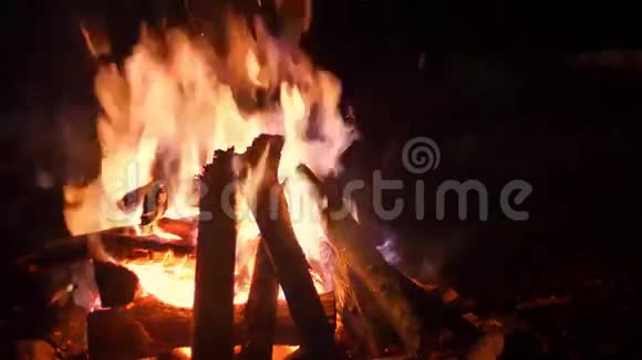 火的火焰点燃了篝火之夜火花燃烧着原木落着雪的特写镜头视频的预览图
