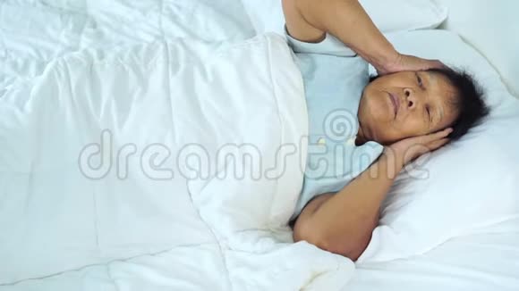 患有失眠症的老妇人正试图睡在床上视频的预览图