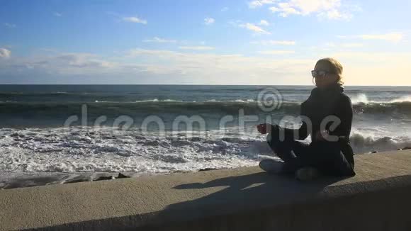 那个女人在暴风雨中在海滩上冥想平衡抵抗压力视频的预览图