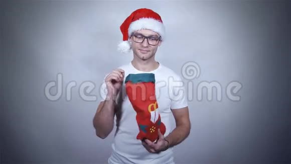 圣诞老人戴着红帽子的家伙拿着并打开礼物视频的预览图