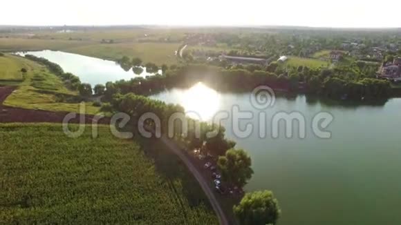 在阳光明媚的一天一条大河穿过绿色的田野俯瞰一个小镇的美景视频的预览图