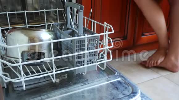 一个女人把盘子放在洗碗机的架子上特写镜头4K慢动作视频的预览图
