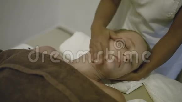 年轻女子在水疗中心做头部按摩视频的预览图