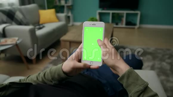 男人在家坐在沙发上用智能手机加绿色锁屏视频的预览图