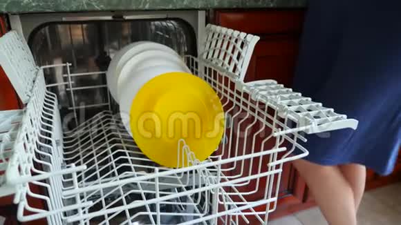 一个女人把盘子放在洗碗机的架子上特写镜头4K慢动作视频的预览图
