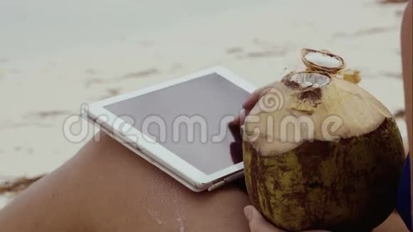女人用触摸板喝椰子饮料视频的预览图