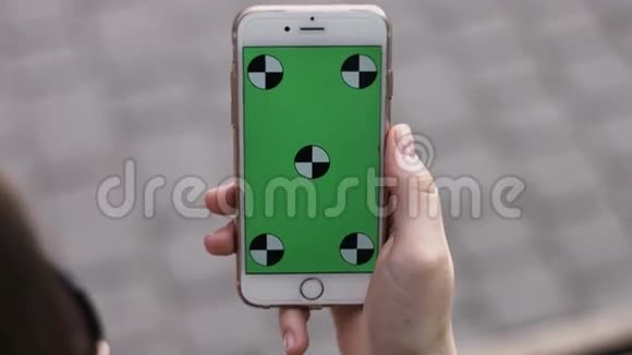 智能手机用手拿着绿色屏幕Chroma键快关门跟踪运动垂直的公园瓷砖地板绿草视频的预览图