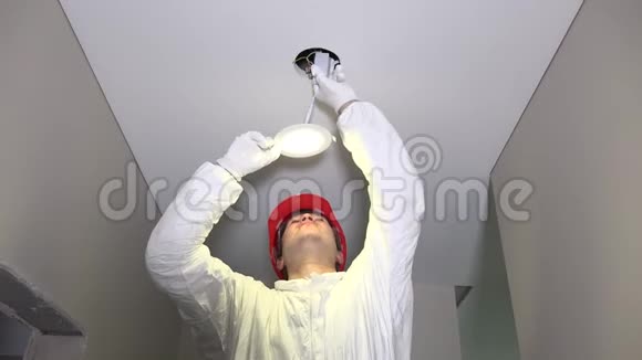 戴头盔的人在天花板上安装铅灯视频的预览图